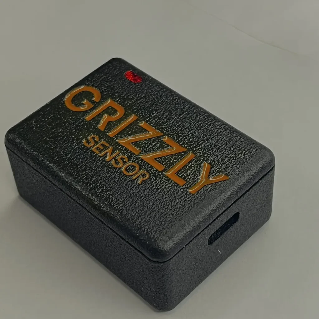 Detalhe do gabinete texturizado do Grizzly Sensor, com a abertura lateral do conector de recarga